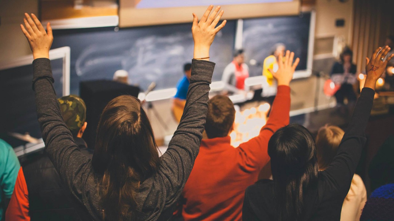 students worshipping in a classroom